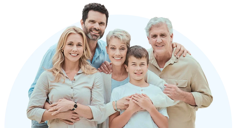 A cheerful family group of six poses closely against a white background. They smile warmly, conveying a sense of togetherness and happiness.