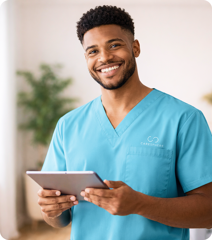 Smiling caregiver holding a tablet indoors.